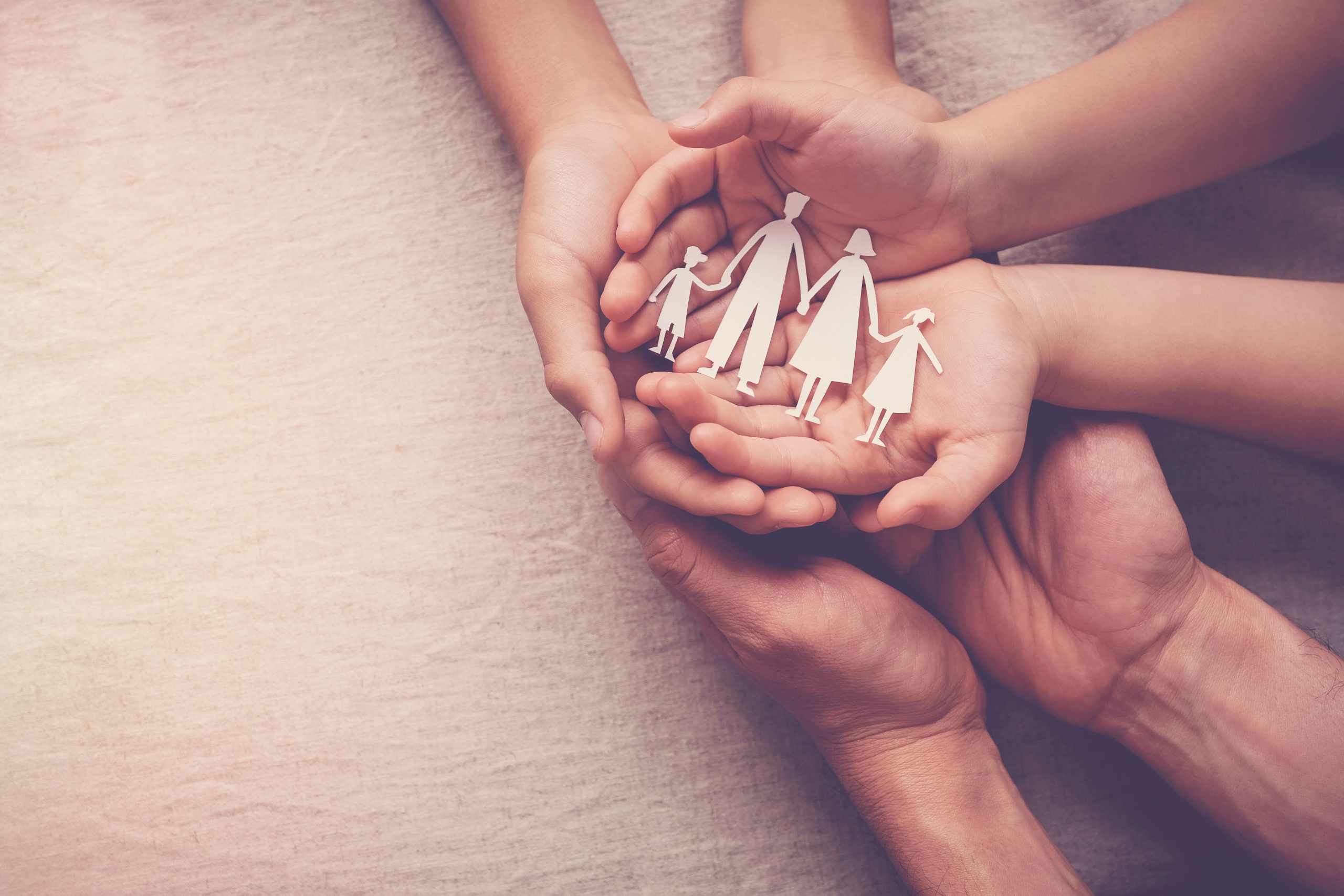 family holding hands and a paper cutout family